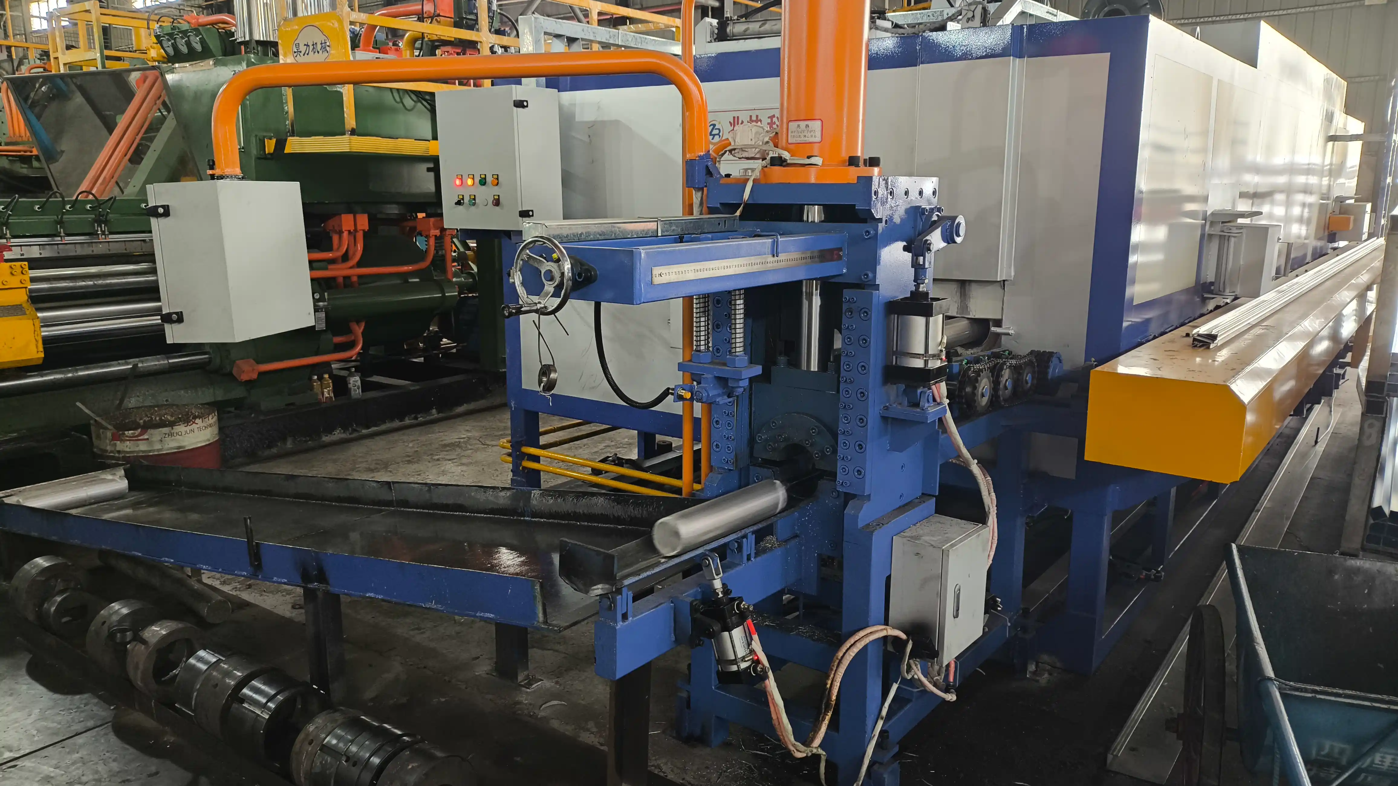 Aluminum billet heating furnace and automatic hot log shear feeding a cylindrical aluminum billet onto the extrusion conveyor