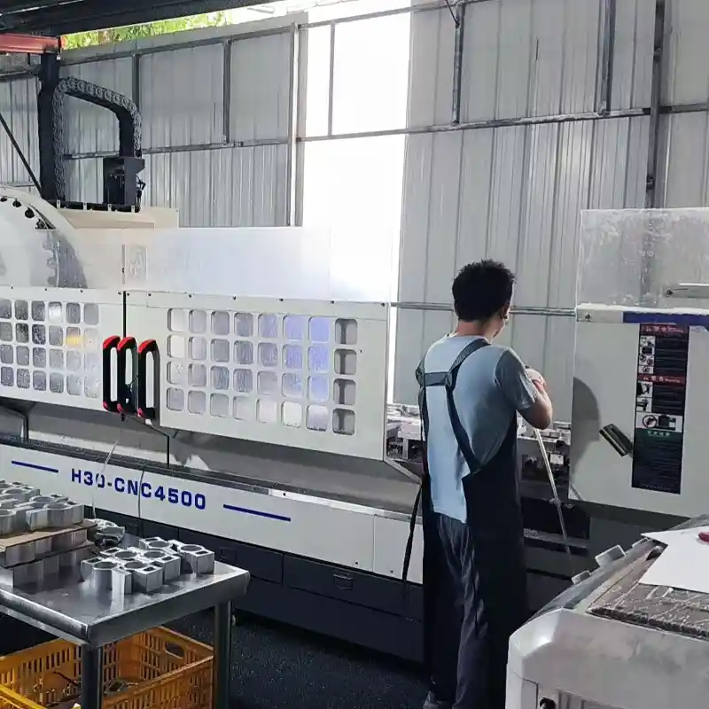 Operator monitoring a heavy-duty CNC machining center for precision aluminum parts fabrication.