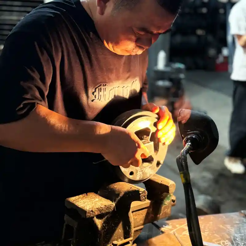 Skilled technician manually polishing an aluminum extrusion die to ensure flawless profile surfaces.