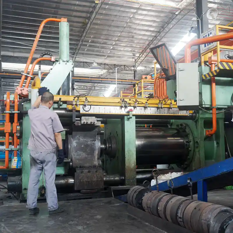 Industrial worker operating a heavy-duty aluminum extrusion press machine in the manufacturing facility.